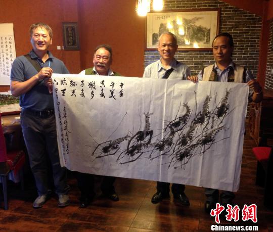 台湾画家杨信弘(左2)画群虾赠予云南当地人士 台湾画家杨信弘(左2)画群虾赠予云南当地人士