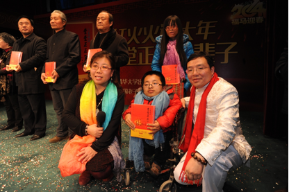 作者冯承平、海燕给到场的部委领导及艺术家基金会资助的两位脑瘫患儿赠书
