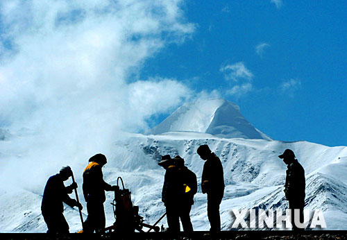青藏铁路建设者在西藏桑典康桑雪山脚下整道(2005年6月8日摄)。 青藏铁路从西宁至拉萨全长1956公里,是世界上海拔最高、线路最长、穿越冻土里程最长的高原铁路。把铁路修进西藏是几代中国人的梦想,但这一想法直到新中国成立后才逐渐变为现实。青藏铁路一期工程西宁至格尔木段于1958年开工,1984年交付营运。但限于当时国家的经济实力以及高原、冻土等筑路技术难题尚未解决,格尔木至拉萨段被迫停建。2001年6月,国家总投资330.9亿元动工修建青藏铁路二期工程。这一工程跨越昆仑山、唐古拉山,通过多年冻土层和大片“生命禁区”,是人类铁路建设史上亘古未有的穿越。它的建成将为神秘而古老的青藏高原带来新的生机和活力! 新华社发