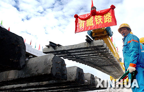 一名青藏铁路建设者正在指挥铺轨。2005年8月24日,随着青藏铁路在海拔5072米处成功铺轨,中国人创造了世界铁路最高点的纪录(资料照片)。 青藏铁路从西宁至拉萨全长1956公里,是世界上海拔最高、线路最长、穿越冻土里程最长的高原铁路。把铁路修进西藏是几代中国人的梦想,但这一想法直到新中国成立后才逐渐变为现实。青藏铁路一期工程西宁至格尔木段于1958年开工,1984年交付营运。但限于当时国家的经济实力以及高原、冻土等筑路技术难题尚未解决,格尔木至拉萨段被迫停建。2001年6月,国家总投资330.9亿元动工修建青藏铁路二期工程。这一工程跨越昆仑山、唐古拉山,通过多年冻土层和大片“生命禁区”,是人类铁路建设史上亘古未有的穿越。它的建成将为神秘而古老的青藏高原带来新的生机和活力! 新华社发