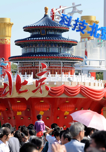 10月2日,游客在“北京之歌”彩车前参观留影。 据了解,在10月1日国庆群众游行中出现的彩车将从2日至7日在天安门广场进行展示。这些彩车充分展示出新中国成立60年来取得的辉煌成就,表达了56个民族的群众对伟大祖国的衷心祝福。 新华社记者 唐召明 摄