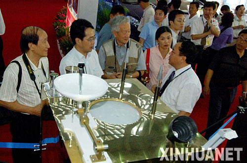 10月13日,几名前来参观的专业人员在“嫦娥一号”人造月球卫星模型前交谈。